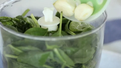 Chef adds garliс into the blender with spinach. Stock Footage 90994449