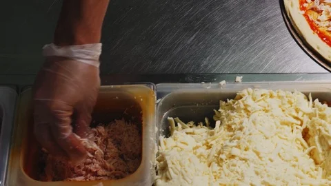 Chef adds ham to pizza with sauce and cheese on table Stock Footage 121610172