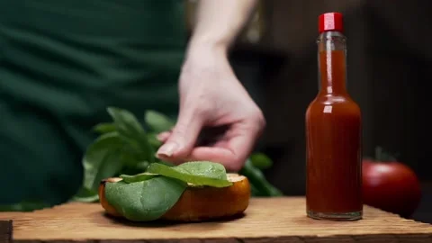 Chef adds leafs of the spinach to the burger Video stock 143594091