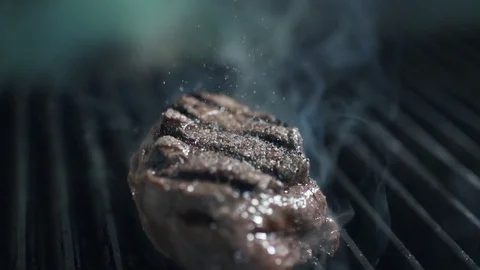 Chef adds pepper to the roasting beef steak, smoke and fire, grilled meat, slow Stock Footage 81367332