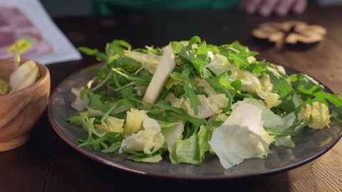 Chef adds pieces of pear to the vegetable salad Stock Footage 143776518