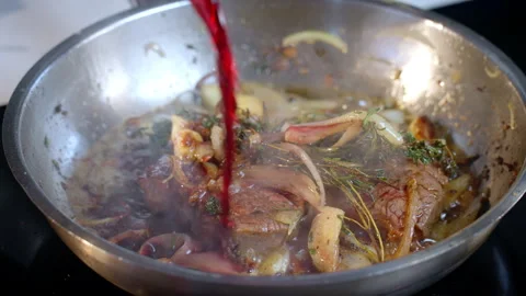 The chef adds red wine to a steak that is being pan-fried with spices. Stock Footage 296798666