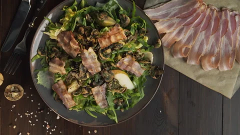 Chef adds roasted slice of bacon to the vegetable salad Stock Footage 143776482