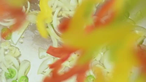 Chef adds sliced green, red and yellow bell peppers into frying pan. Stock Footage 162059672