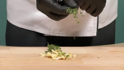 The chef adds spices to the garlic Vídeos de archivo 306803691