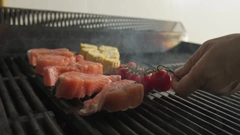 Chef adds tomatoes and grilled vegetables to grilled fish Stock Footage 254564486