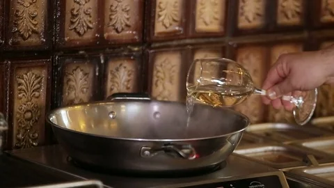 Chef adds white wine to the dish Stock Footage 74716099