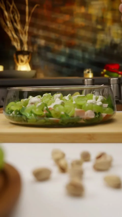 Chef adds yogurt dressing to a fresh salad with grapes and turkey Stock Footage 310928573
