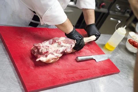 The chef also prepares lamb shank dishes. The process of cooking lamb shank male Fotos de archivo