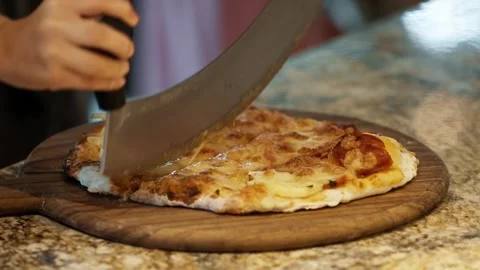 Chef and child cutting fresh pizza together during pizza making lesson Stock Footage 317734639