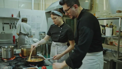 Chef and Female Apprentice Cooking Food Together in Restaurant Kitchen 스톡 동영상 270144249