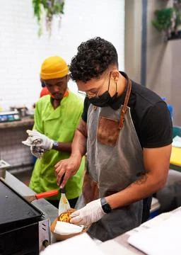 A chef and his assistant prepare tacos at a food stall Foto stock