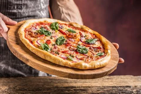 Chef and pizza. Chef offering pizza in hotel or restaurant Stock Photos