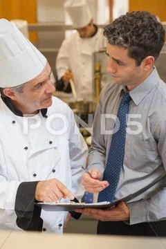Chef and waiter having a discussion Stock Photos