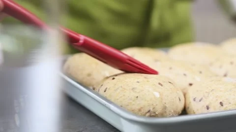 Chef apply olive oil on bread rolls using culinary brush, before baking. Stock Footage 153484056