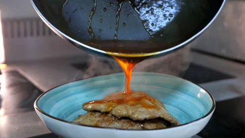 Chef applying sauce on the meat cutlets, chops from the frying pan Stock Footage 132193889