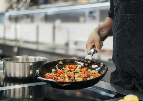 Chef with apron cooking dish kitchen. High quality photo Stock Photos