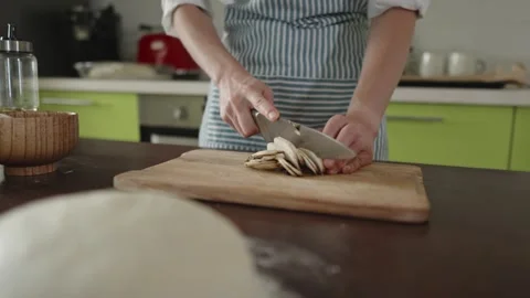 The chef in apron cuts mushrooms with a knife Stock Footage 280160751