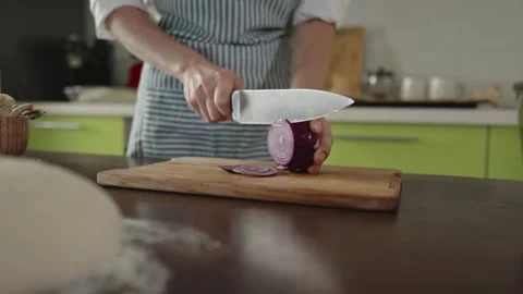 The chef in apron cuts an onion with a knife. Stock Footage 280160927