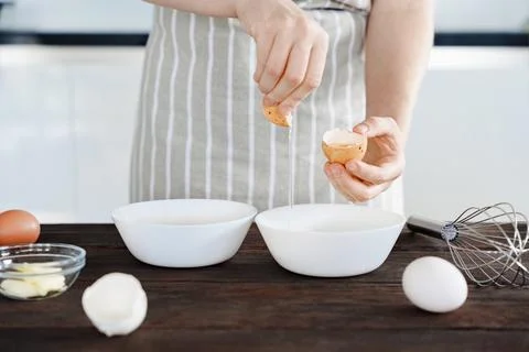 Chef In Apron At Kitchen Separating Egg White Into Bowl for Baking Stock Photos