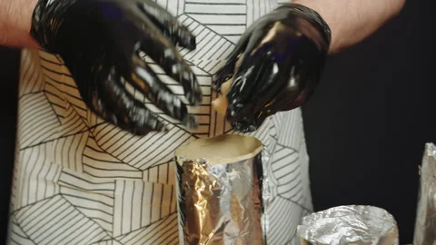 A chef in apron takes the dough from the pan and put it into foil containers Video stock 330536847