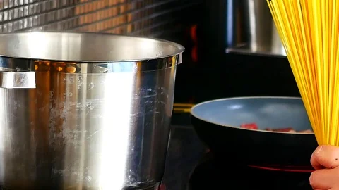 Chef are cooked spaghetti, Boil spaghetti and Bacon frying in a pan. Stock Footage 79609524