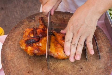 Chef are using Kitchen knife chicken grilled on wood block Stock Photos