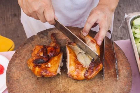 Chef are using Kitchen knife chicken grilled on wood block Stock Photos