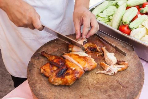 Chef are using Kitchen knife chicken grilled on wood block Stock Photos