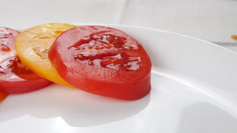 Chef arranges fresh yellow and red tomato slices on a white plate. Vídeo Stock 341474826