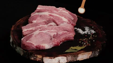 A chef arranges pieces of raw fresh pork meat for frying (pork steak), Stock Footage 264839544