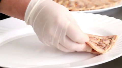 Chef arranges slices of chicken roulade meat on a plate Stock Footage 98798038
