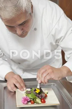 Chef Arranging Edible Flowers On Salad Stock Photos