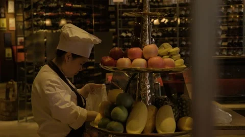 Chef Arranging Fresh Fruit on Display Stand in Beijing Restaurant Interior Scene Stock Footage 345779473