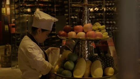 Chef Arranging Fresh Fruit on Display Stand in Beijing Restaurant Interior Scene Stock Footage 345779529