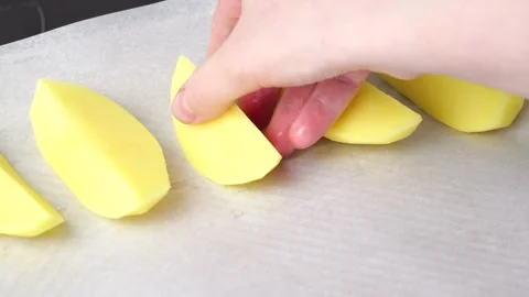Chef arranging potato wedges on baking sheet Stock Footage 305964477