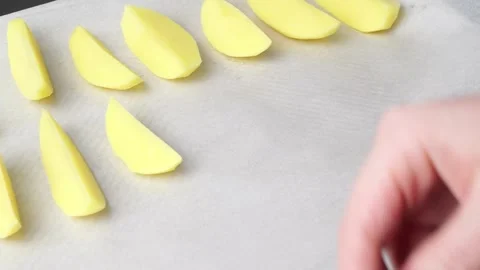 Chef arranging potato wedges on baking sheet Stock Footage 305965100