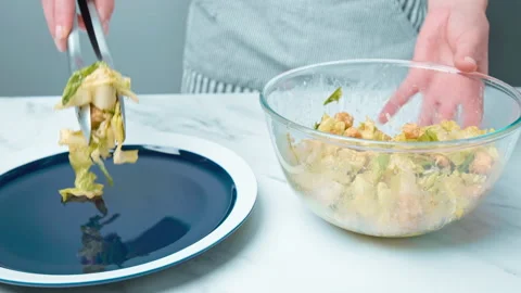 The chef is arranging professionally Caesar Salad in a serving plate in 4K. Stock Footage 140769093