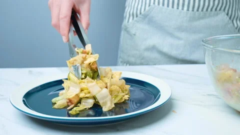 The chef is arranging professionally Caesar Salad in a serving plate in 4K. Stock Footage 140769528