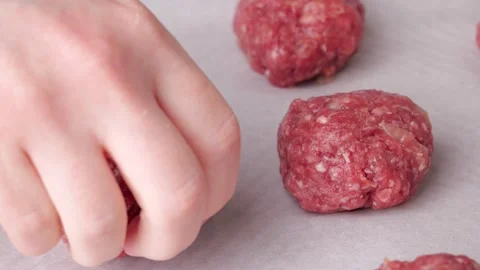 Chef arranging raw meatballs on baking paper in slow motion Stock Footage 305865143