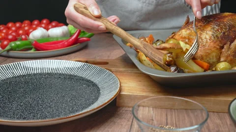 A chef is arranging roasted chicken and vegetables into a serving plate in 4k. Stock Footage 145117976