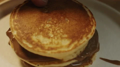 The chef assembles a slide of baked pancakes with chocolate caramel cream 스톡 동영상 151361824