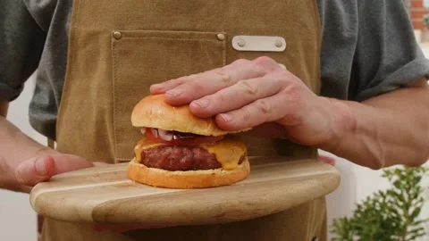 Chef Assembling a Fresh Smash Burger with Cheese and Tomato Stock Footage 302322909