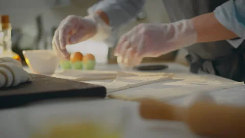 A chef baker in a work apron creates aromatic croissants in an open kitchen. Stock Footage 281418268