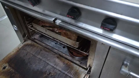 Chef baking lamb shanks in professional kitchen oven 스톡 동영상 323353777