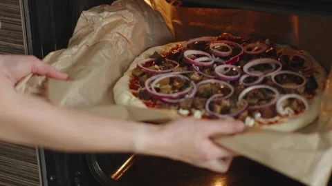 The chef is baking a raw pizza with mushrooms in the oven.  Stock Footage 280158772