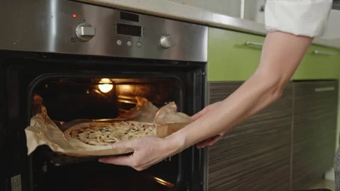 The chef is baking a raw pizza with mushrooms in the oven Stock Footage 280159374