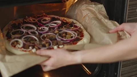 The chef is baking a raw pizza with mushrooms in the oven Video stock 280160256