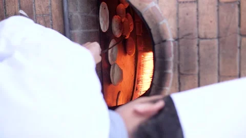 Chef baking traditional Arabic bread inside a fire oven. Stock Footage 200776037