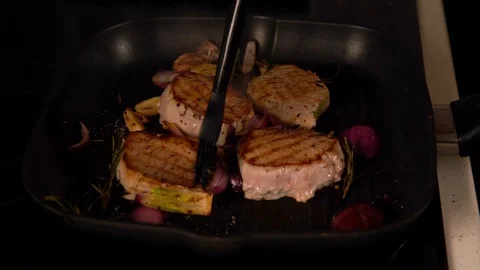 Chef basting grilling meat in a pan Stock Footage 105127801